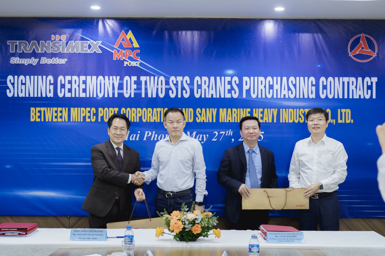 A group of men shaking hands in front of a bannerAI-generated content may be incorrect.