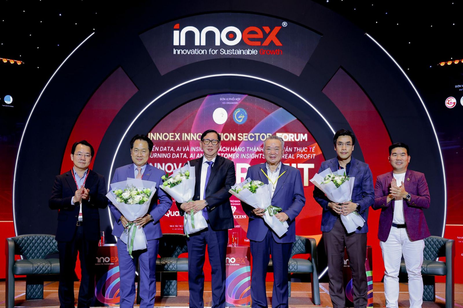 A group of men standing on a stageAI-generated content may be incorrect.